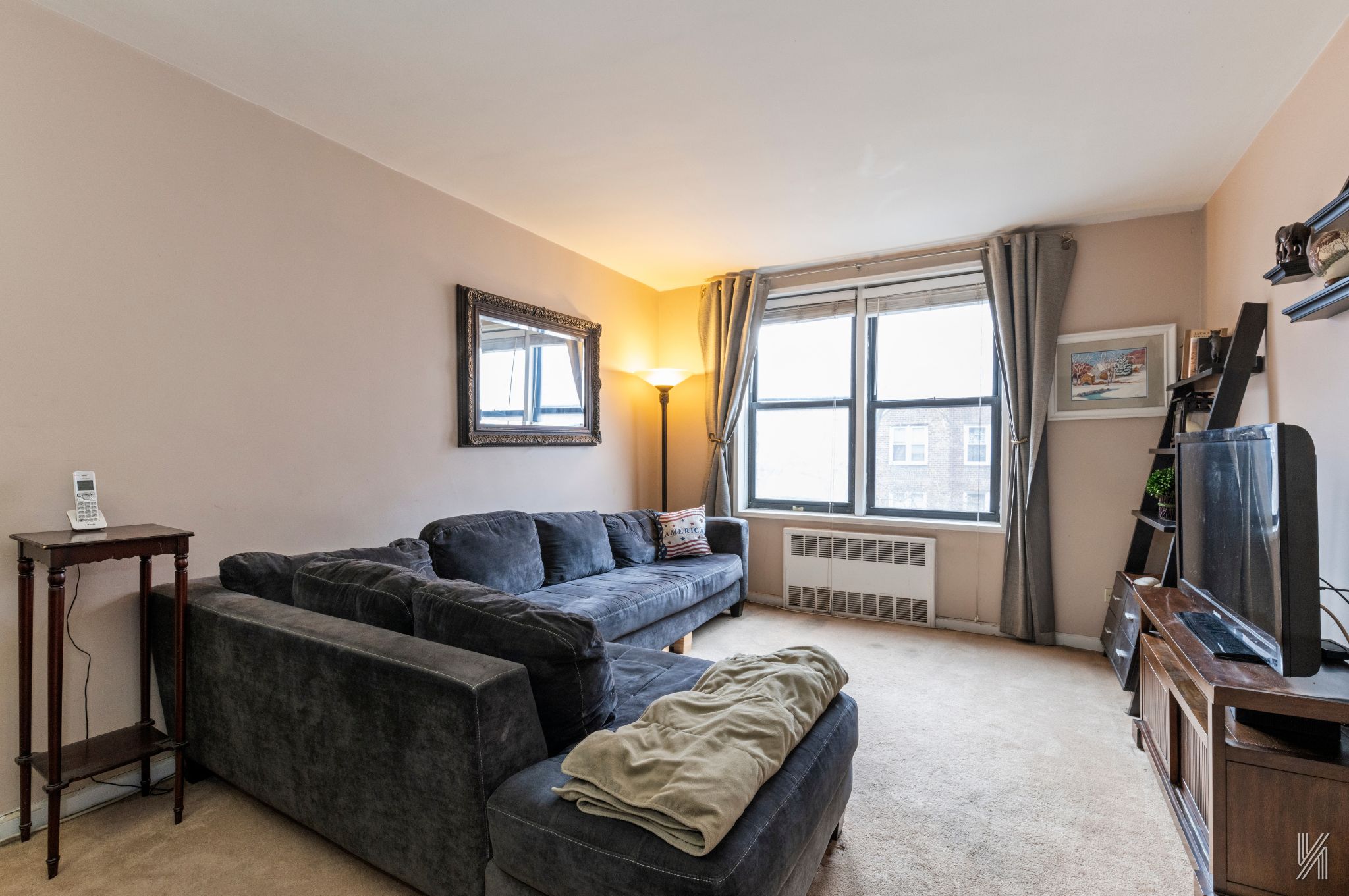 33-27 91st Street, Unit 3J Queens, NY 11372 - Photo 3 of 13 a living room with furniture a flat screen tv and a window
