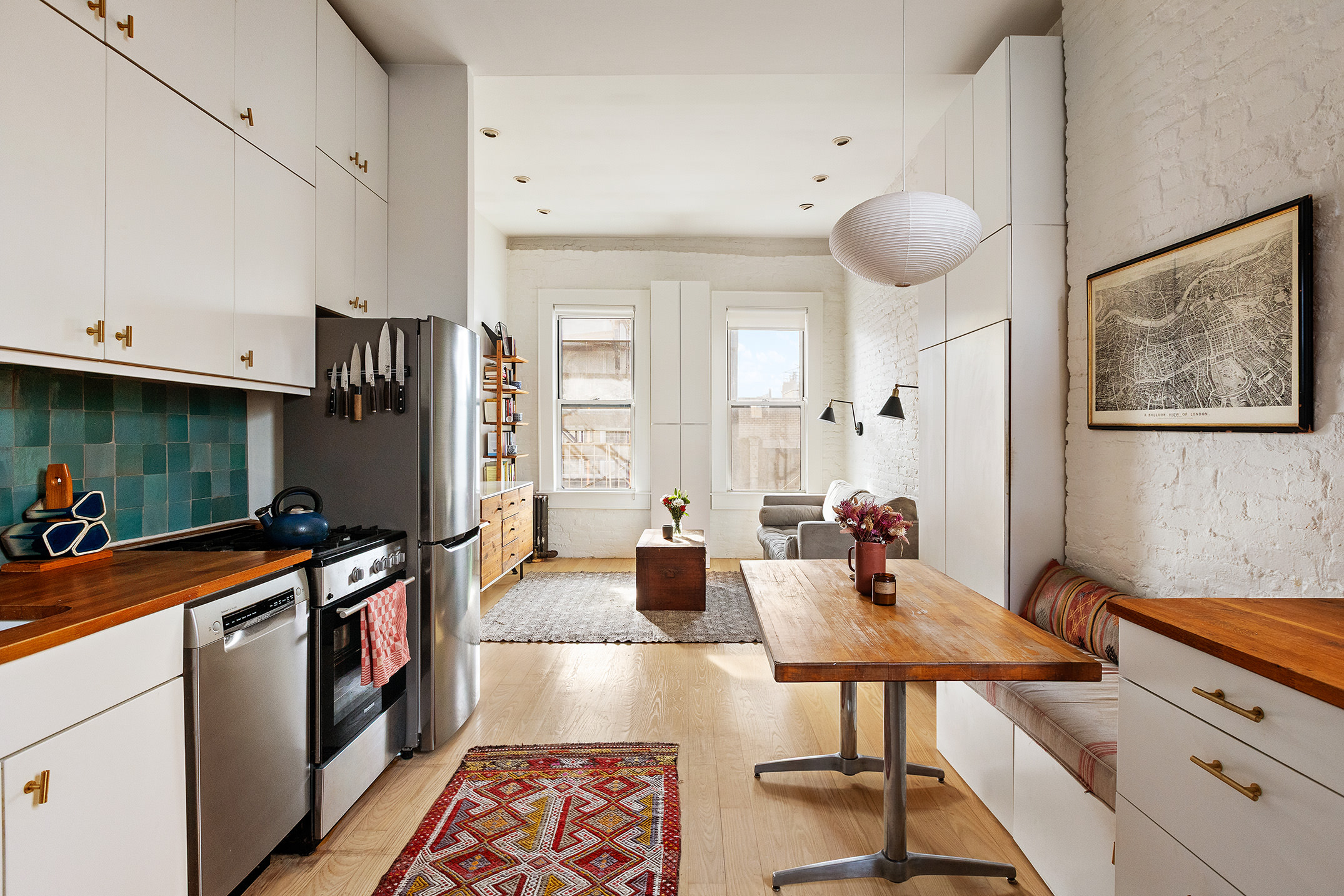 633 East 11th Street, Unit 22 Manhattan, NY 10009 - Photo 1 of 10 a kitchen with a table chairs refrigerator and sink