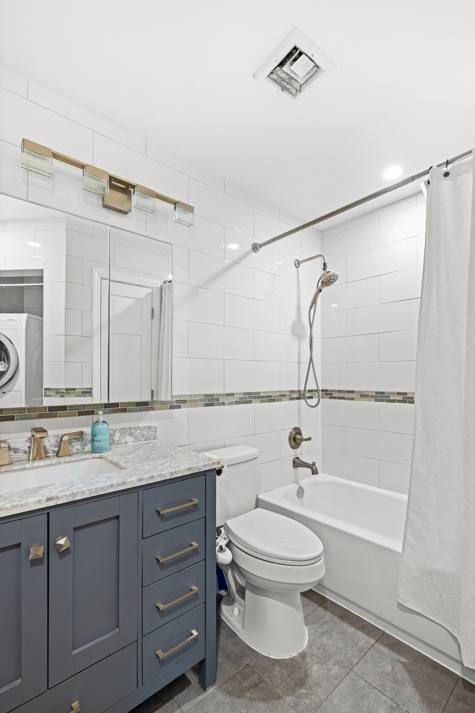 61-20 71st Avenue, Unit J1B Queens, NY 11385 - Photo 10 of 13 a bathroom with a sink a mirror and a shower