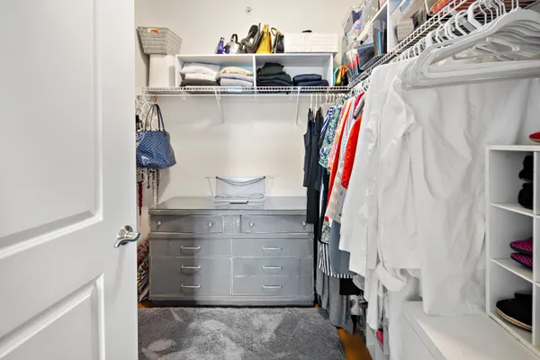a view of walk in closet with clothes and shoes