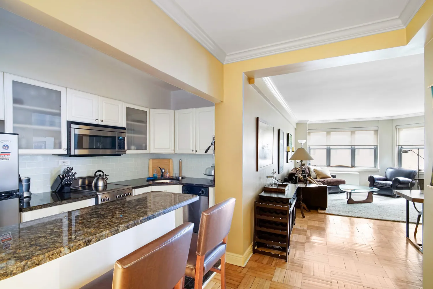 a large kitchen with stainless steel appliances granite countertop a stove top oven a sink a dining table and chairs