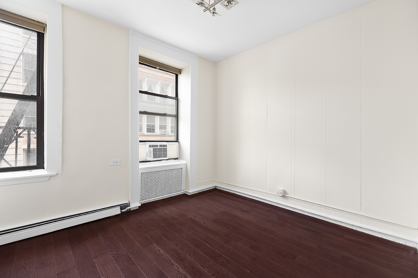 57 Grand Street, Unit 3 Manhattan, NY 10013 - Photo 4 of 6 an empty room with wooden floor and windows