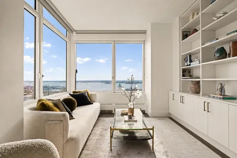 a living room with furniture and a floor to ceiling window