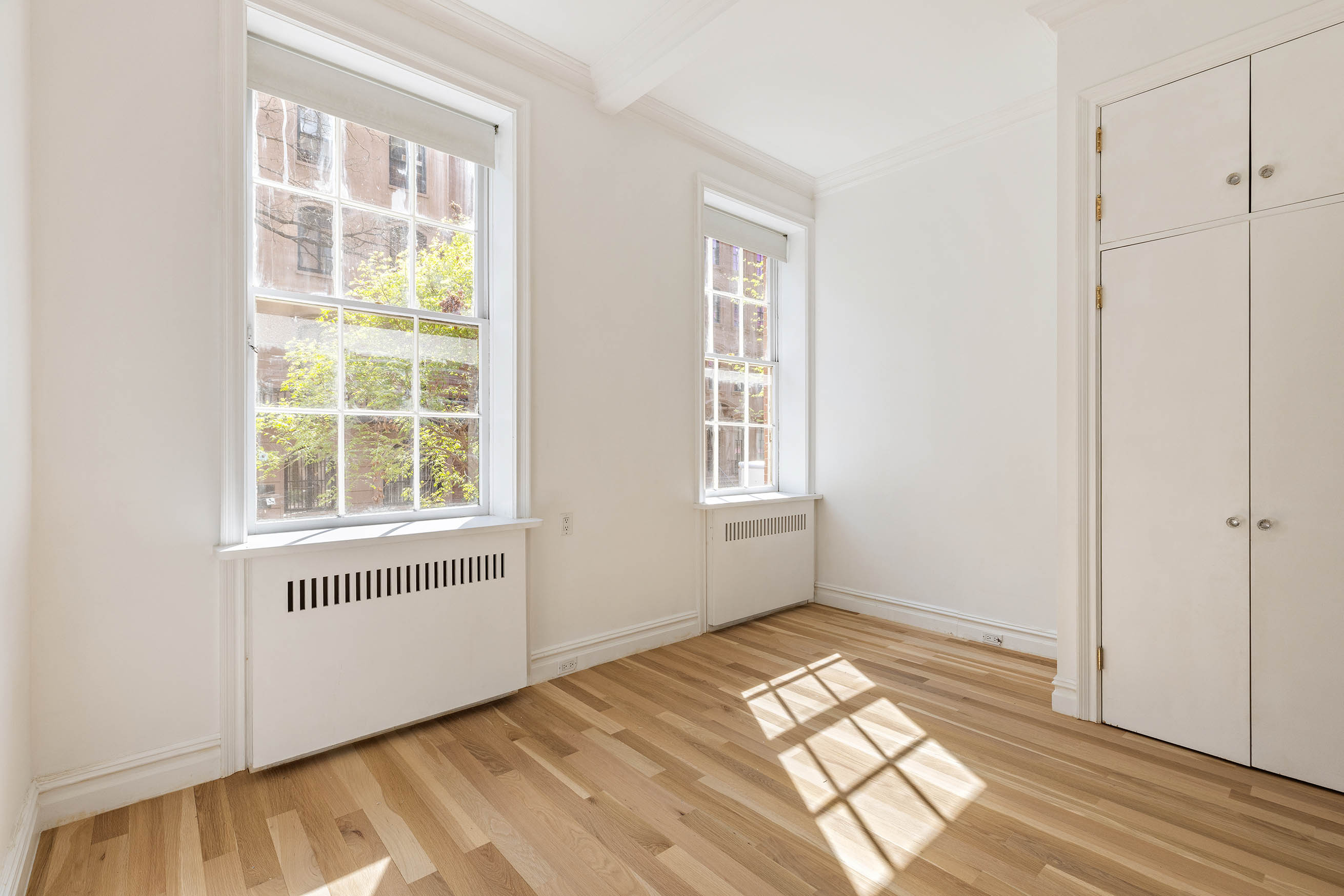 23 West 12th Street, Unit 1 Manhattan, NY 10011 - Photo 9 of 13 an empty room with wooden floor and windows