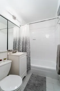 a bathroom with a sink mirror vanity and toilet