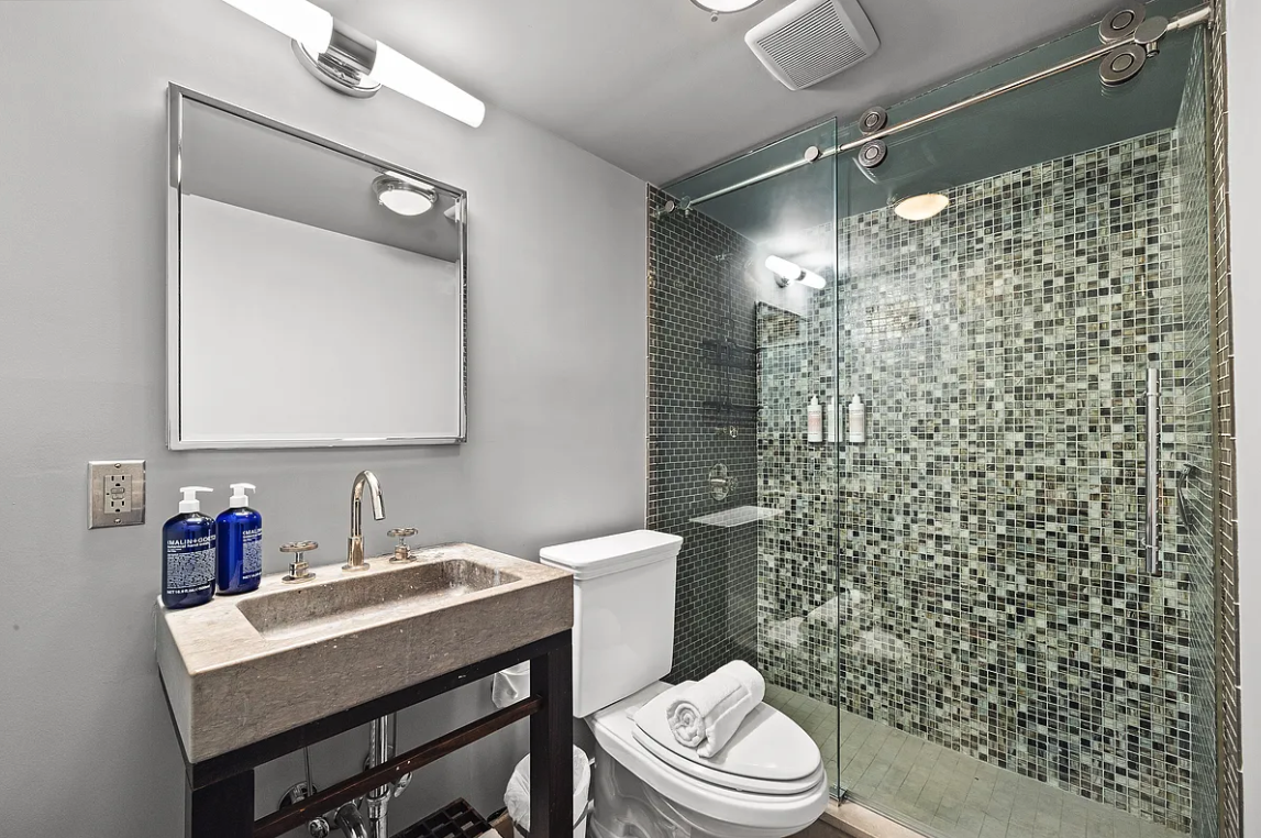 58 Downing Street Manhattan, NY 10014 - Photo 22 of 27 a bathroom with a sink toilet vanity and shower