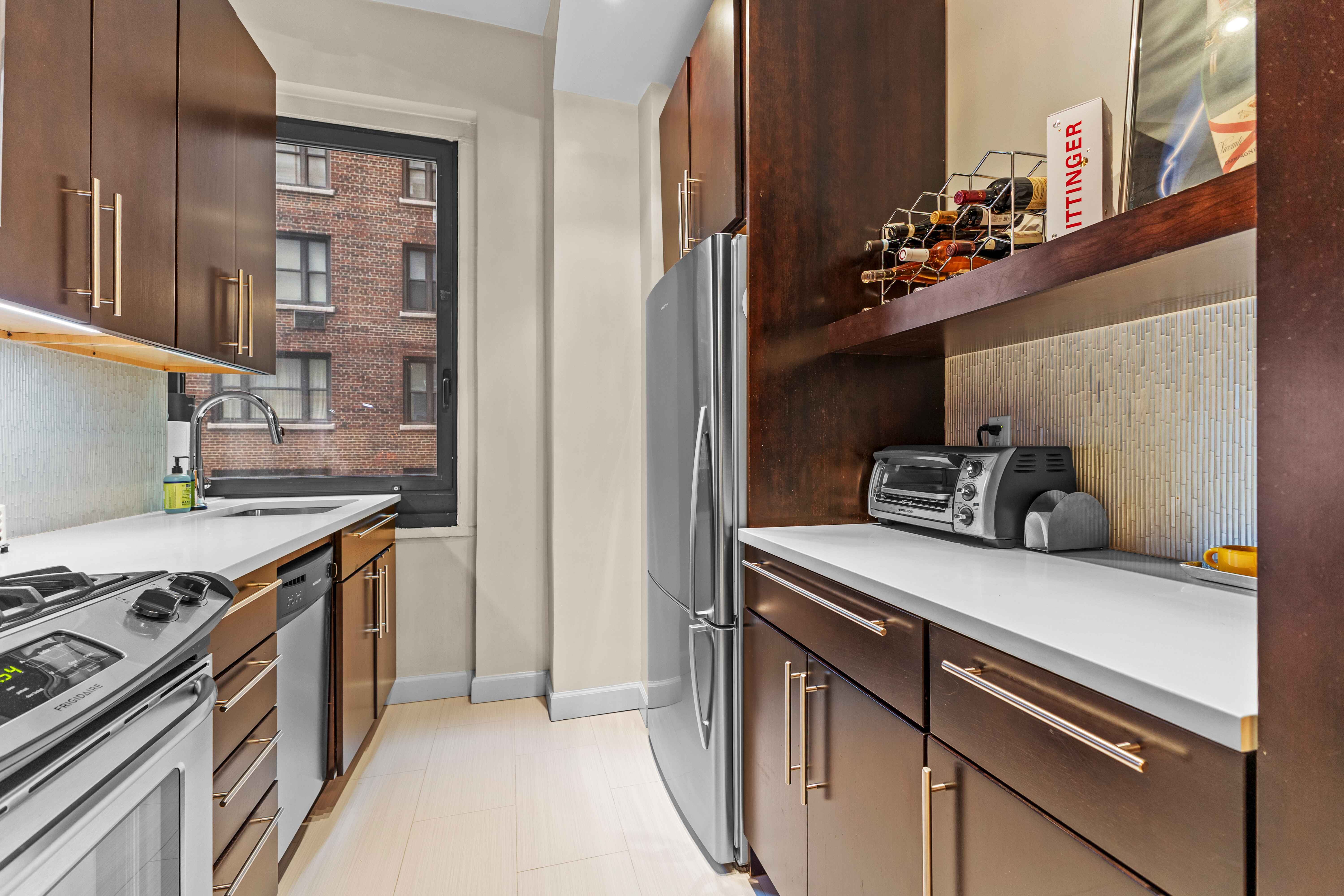 263 West End Avenue, Unit 6E Manhattan, NY 10023 - Photo 6 of 12 a kitchen with stainless steel appliances granite countertop a stove and a refrigerator