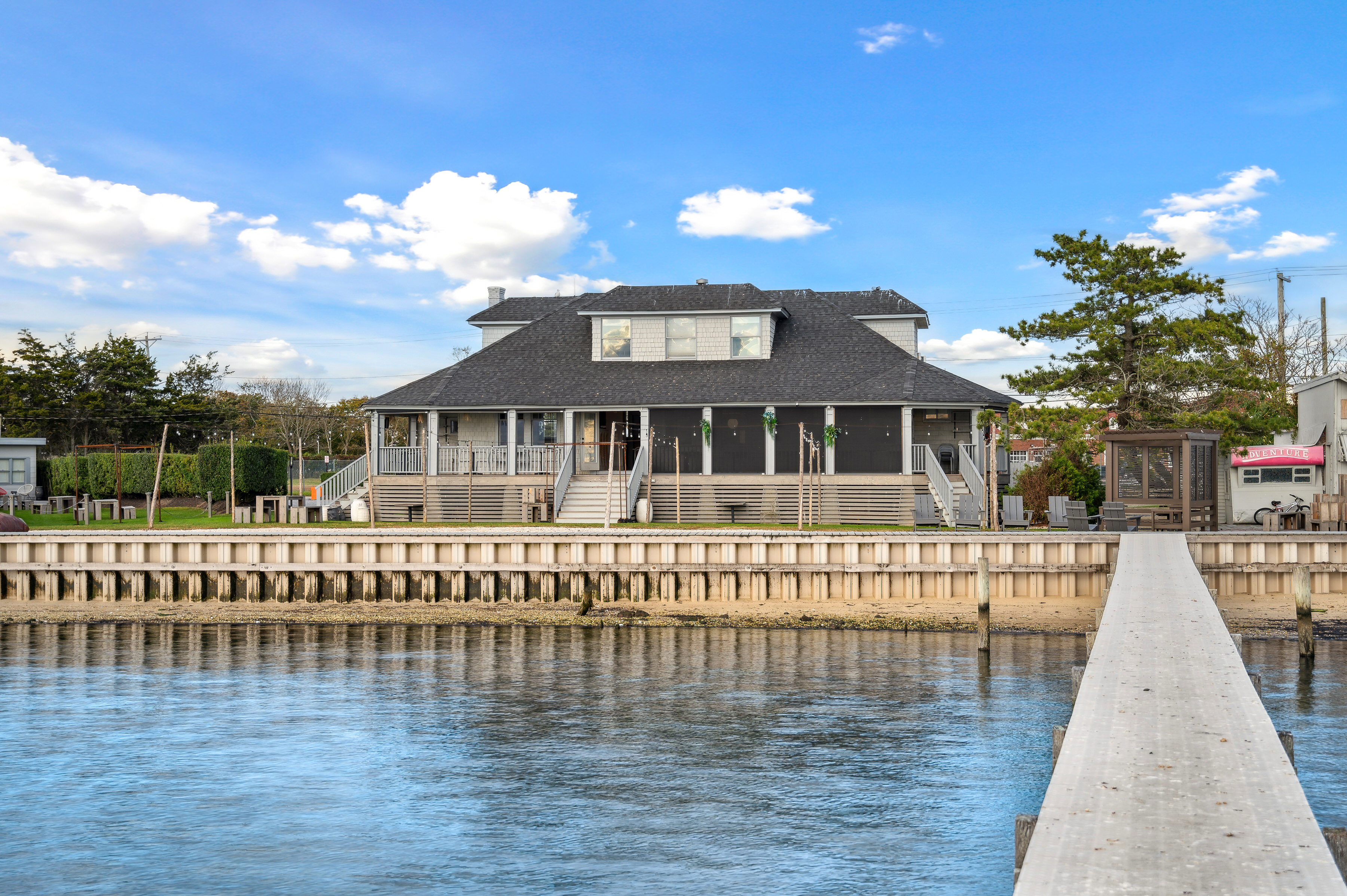 32 Lighthouse Road Hampton Bays, NY 11946 - Photo 10 of 51 a front view of a house with a garden