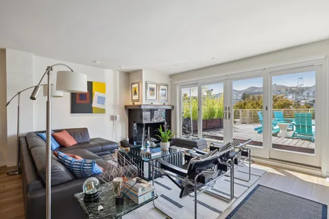 a kitchen with stainless steel appliances granite countertop a refrigerator a sink dishwasher a dining table and chairs with wooden floor