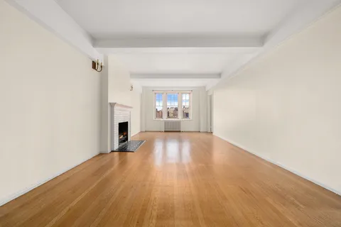 a view of empty room with a fireplace and wooden floor