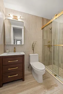a bathroom with a toilet a sink and mirror