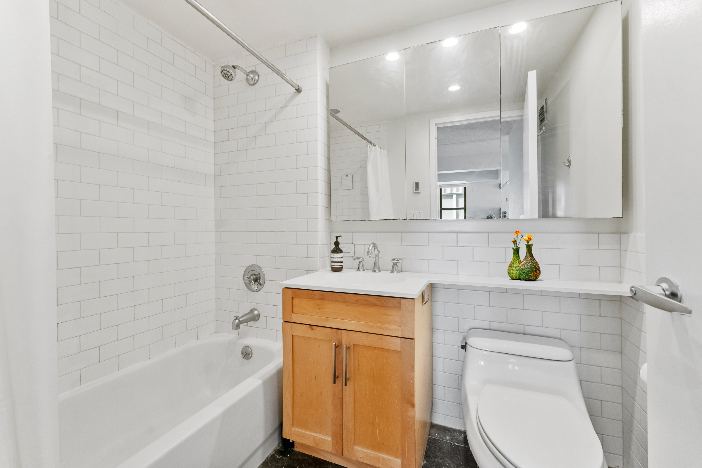 516 West 47th Street, Unit S6L Manhattan, NY 10036 - Photo 7 of 12 a bathroom with a sink a toilet and shower