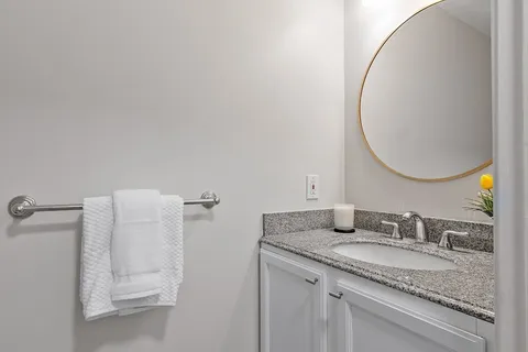 a bathroom with a granite countertop sink and a mirror