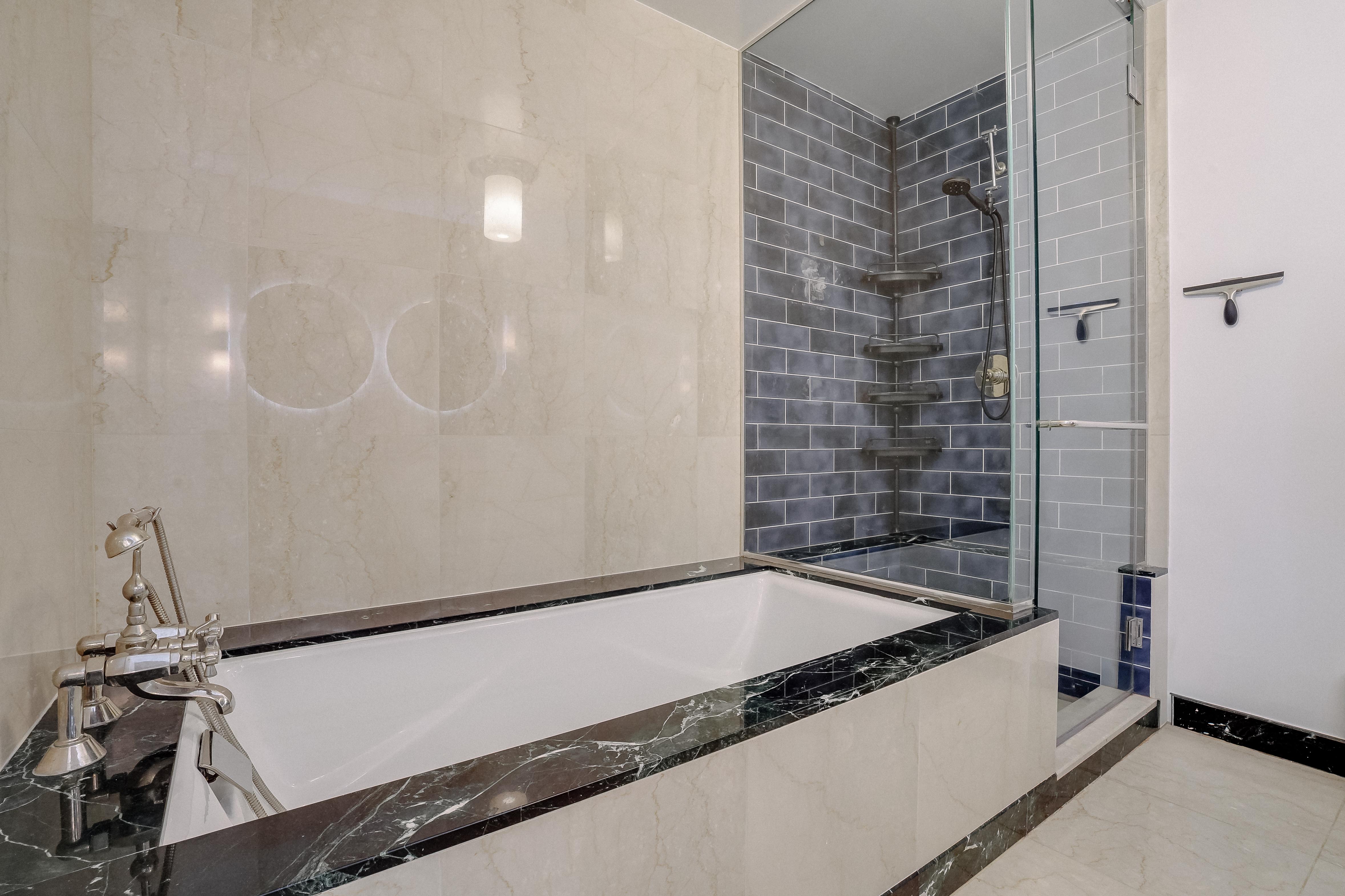 55 Wall Street, Unit PH910 Manhattan, NY 10005 - Photo 8 of 19 a bathroom with a bathtub and shower
