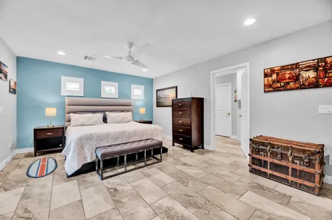 a bedroom with a bed and a lamp on dresser