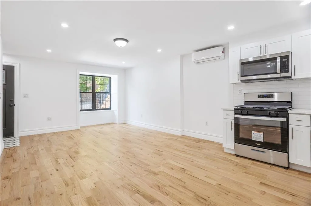 a view of an empty room with a fireplace and a window