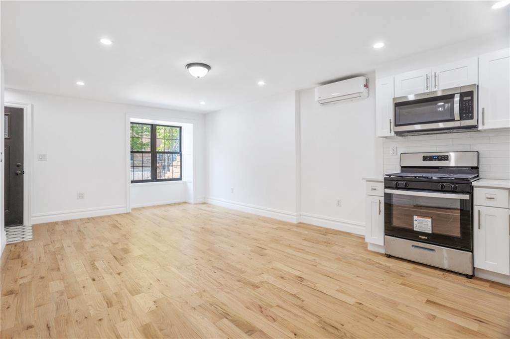 760 Decatur Street, Unit 1 Brooklyn, NY 11233 - Photo 3 of 12 a view of an empty room with a fireplace and a window