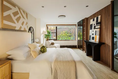 a bedroom with a bed and a large window