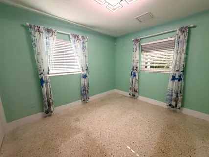 a view of an empty room with a window and a bathroom