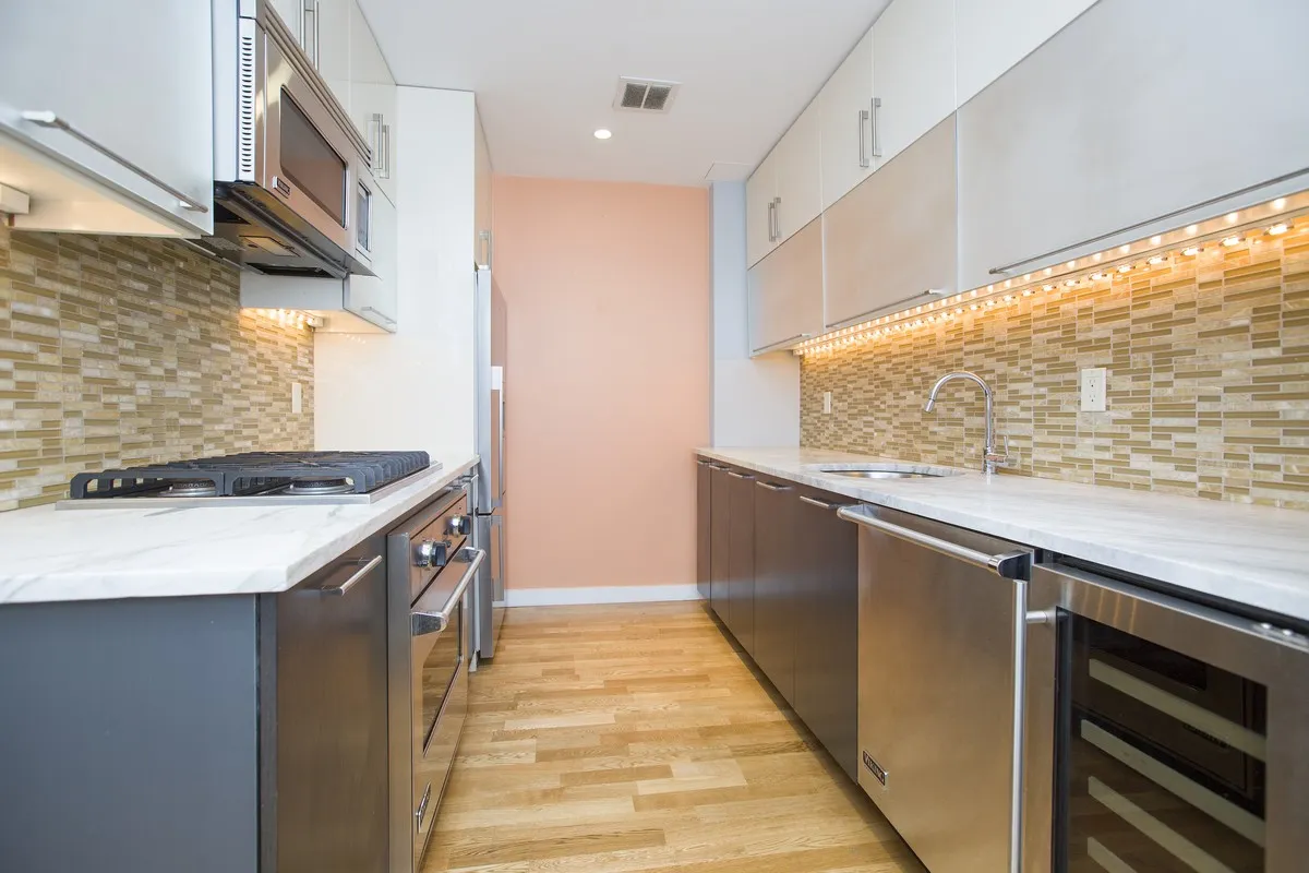 a kitchen with stainless steel appliances granite countertop a sink and a stove