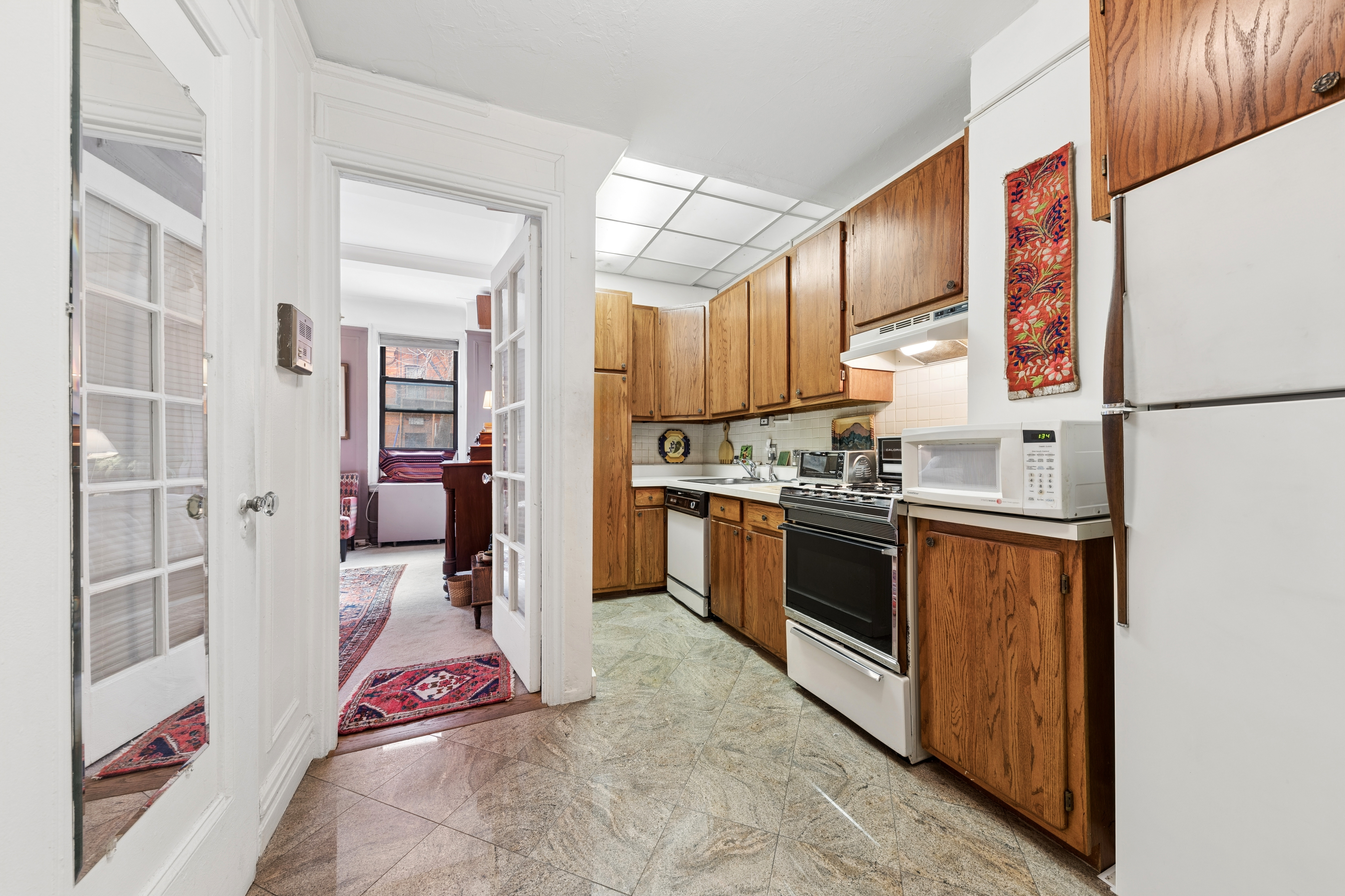 201 West 89th Street, Unit 1E Manhattan, NY 10024 - Photo 3 of 12 a kitchen with stainless steel appliances a refrigerator sink and cabinets