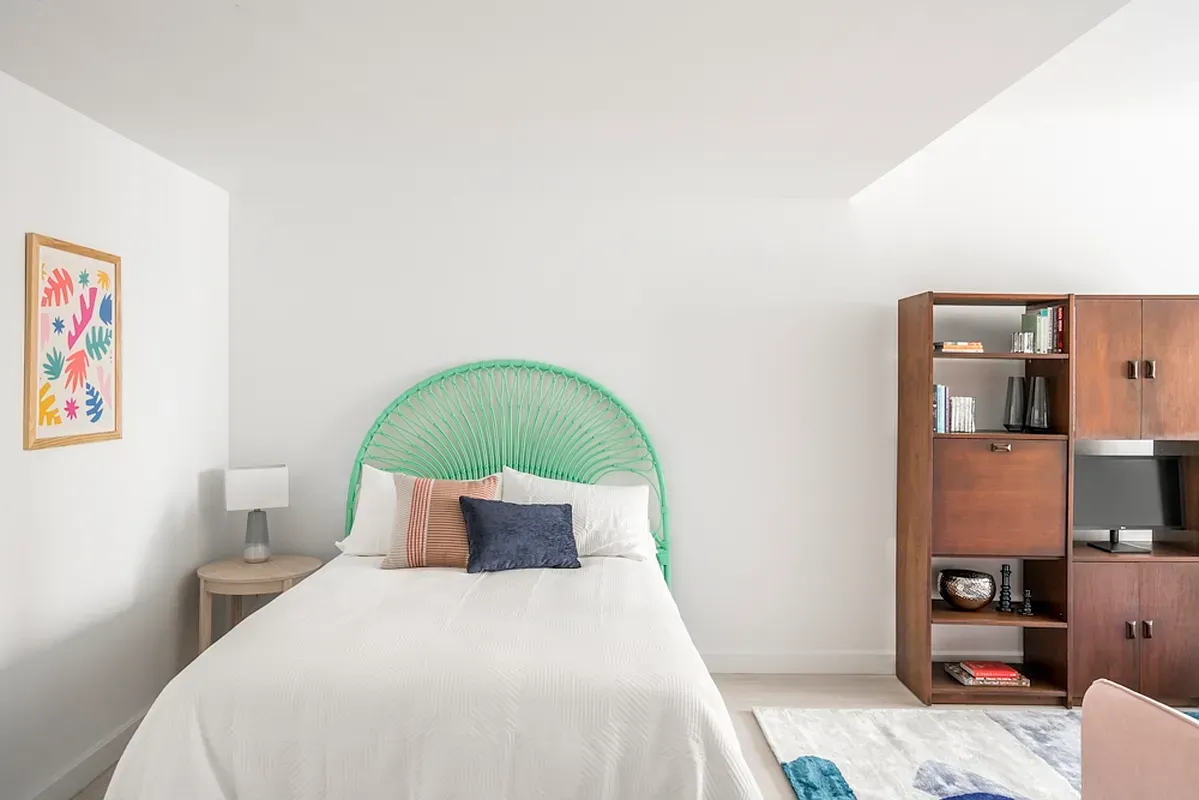 a bedroom with a bed and a painting on the wall