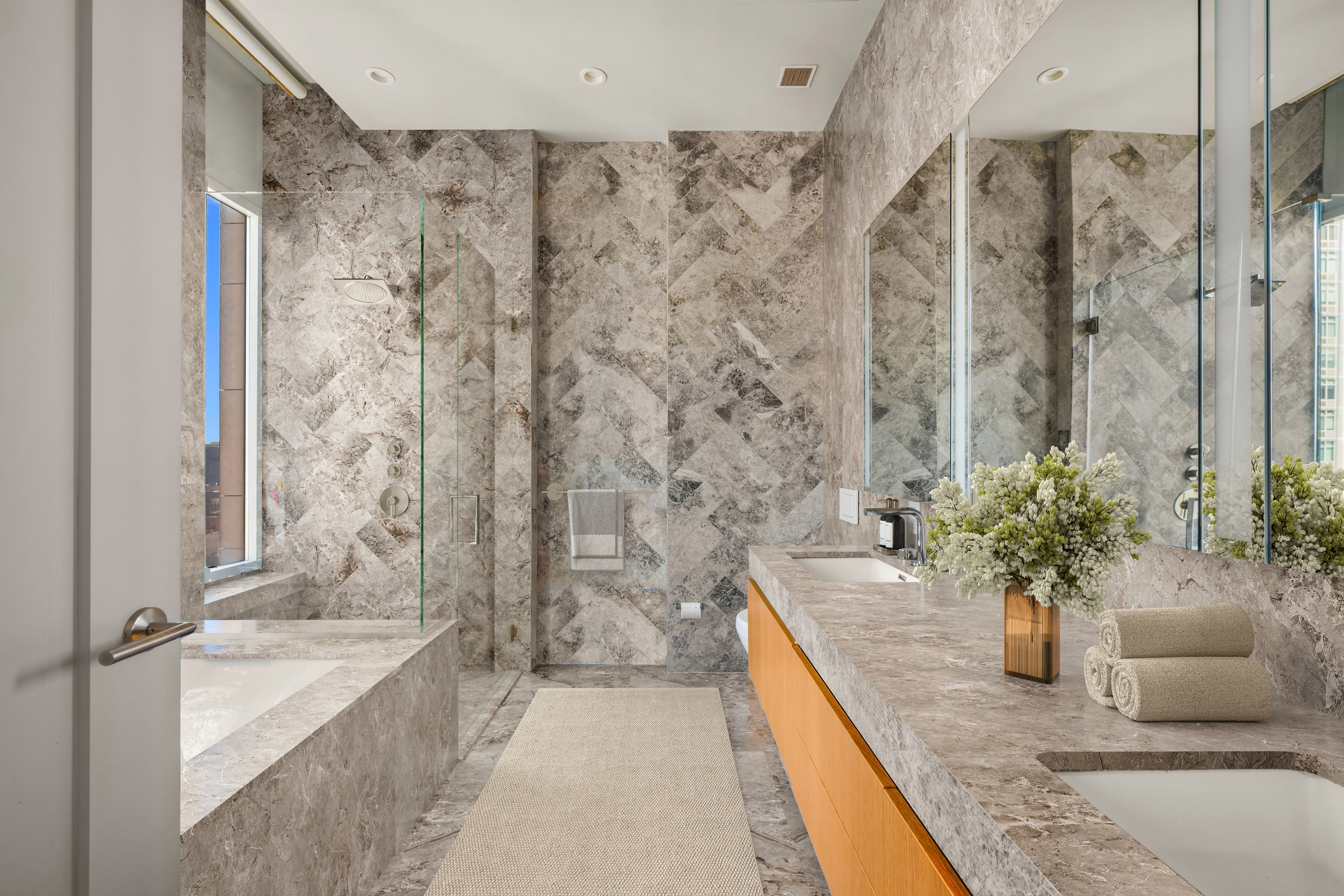 1059 3rd Avenue, Unit 25 Manhattan, NY 10065 - Photo 6 of 13 a large spacious bathroom with a granite countertop tub a sink and a potted plant