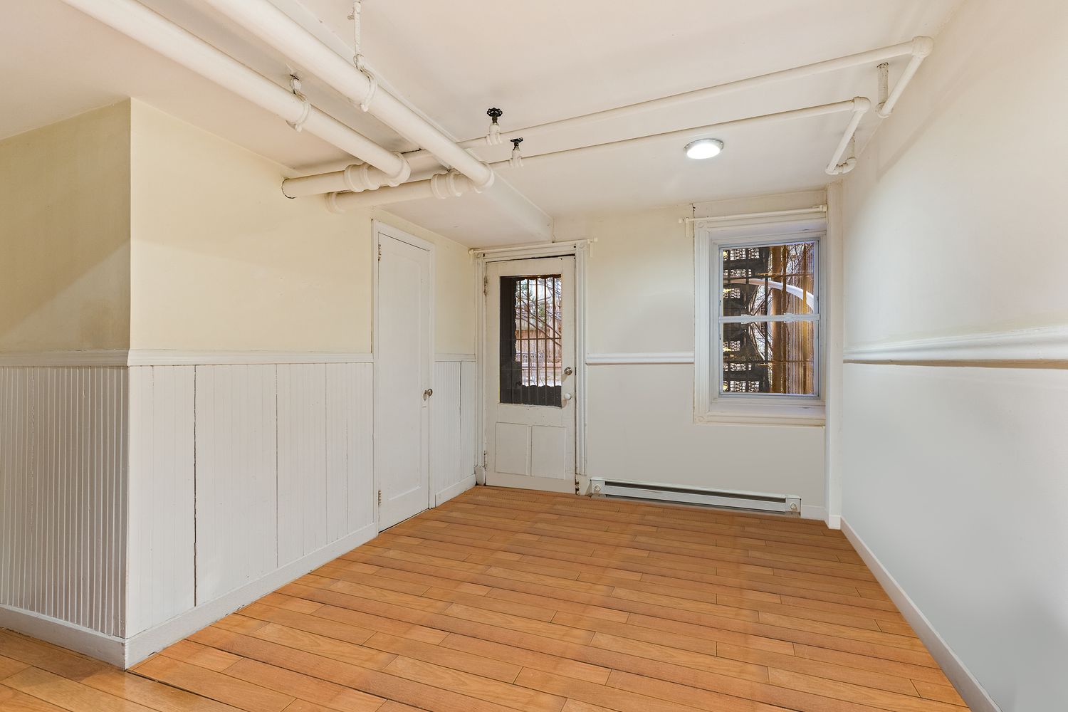 a view of empty room with wooden floor