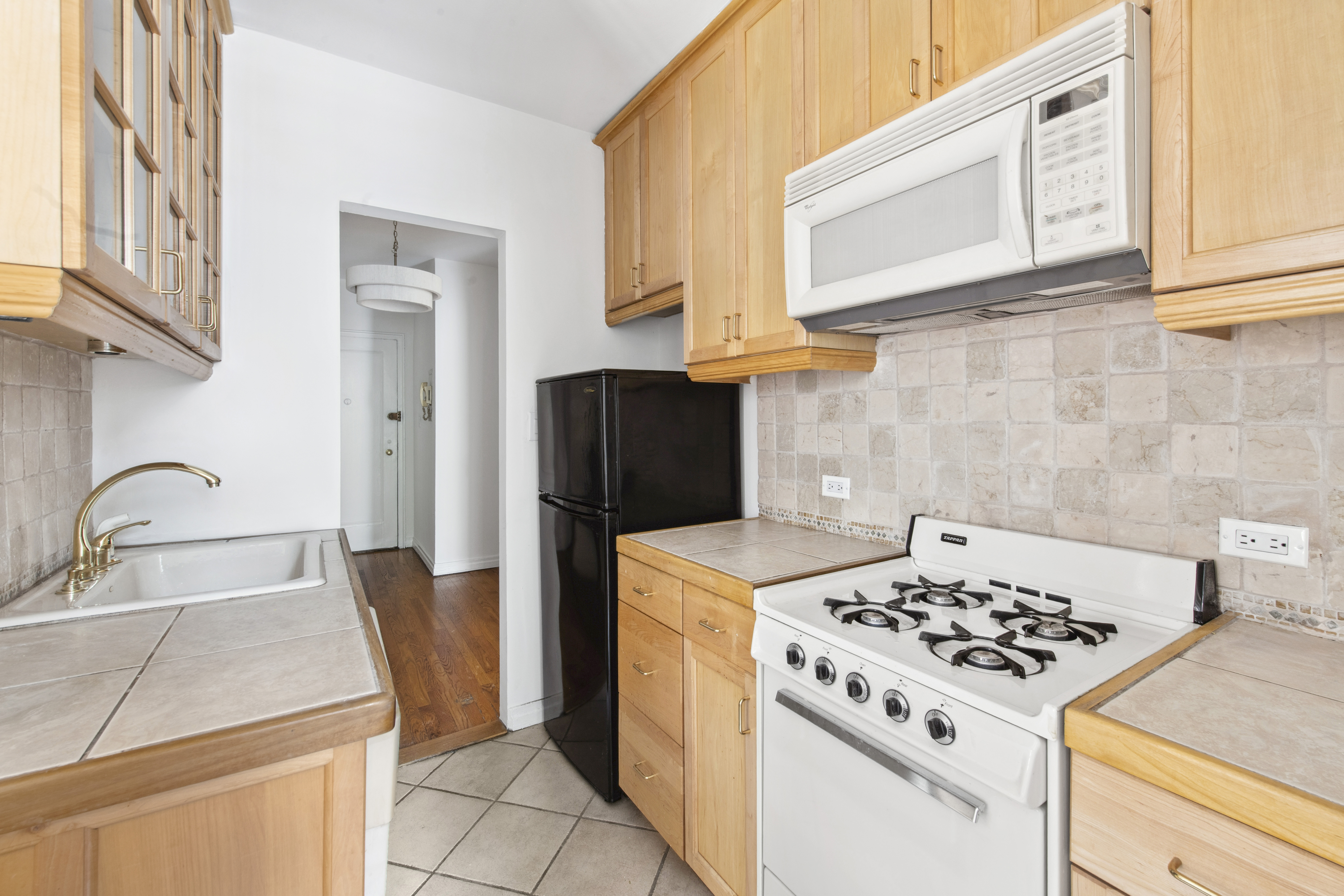 515 East 89th Street, Unit 2E Manhattan, NY 10128 - Photo 9 of 17 a kitchen with stainless steel appliances granite countertop a sink stove and refrigerator