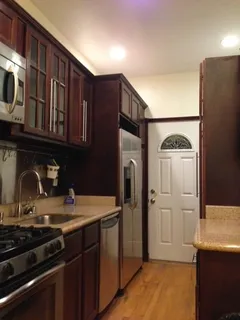 a kitchen with stainless steel appliances granite countertop a refrigerator and a stove top oven