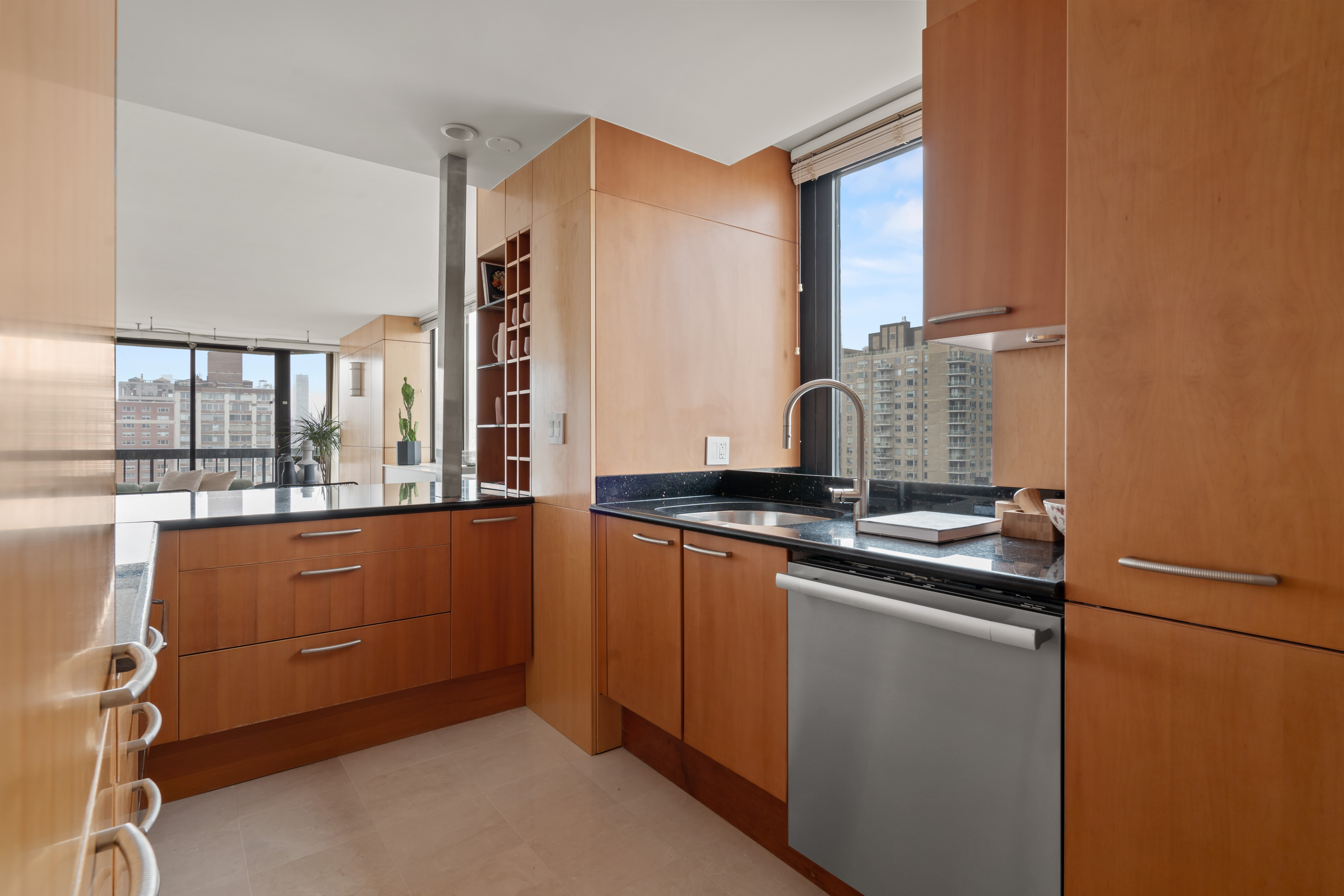 330 East 75th Street, Unit 32A Manhattan, NY 10021 - Photo 6 of 17 a kitchen with stainless steel appliances granite countertop a sink and a stove next to a window