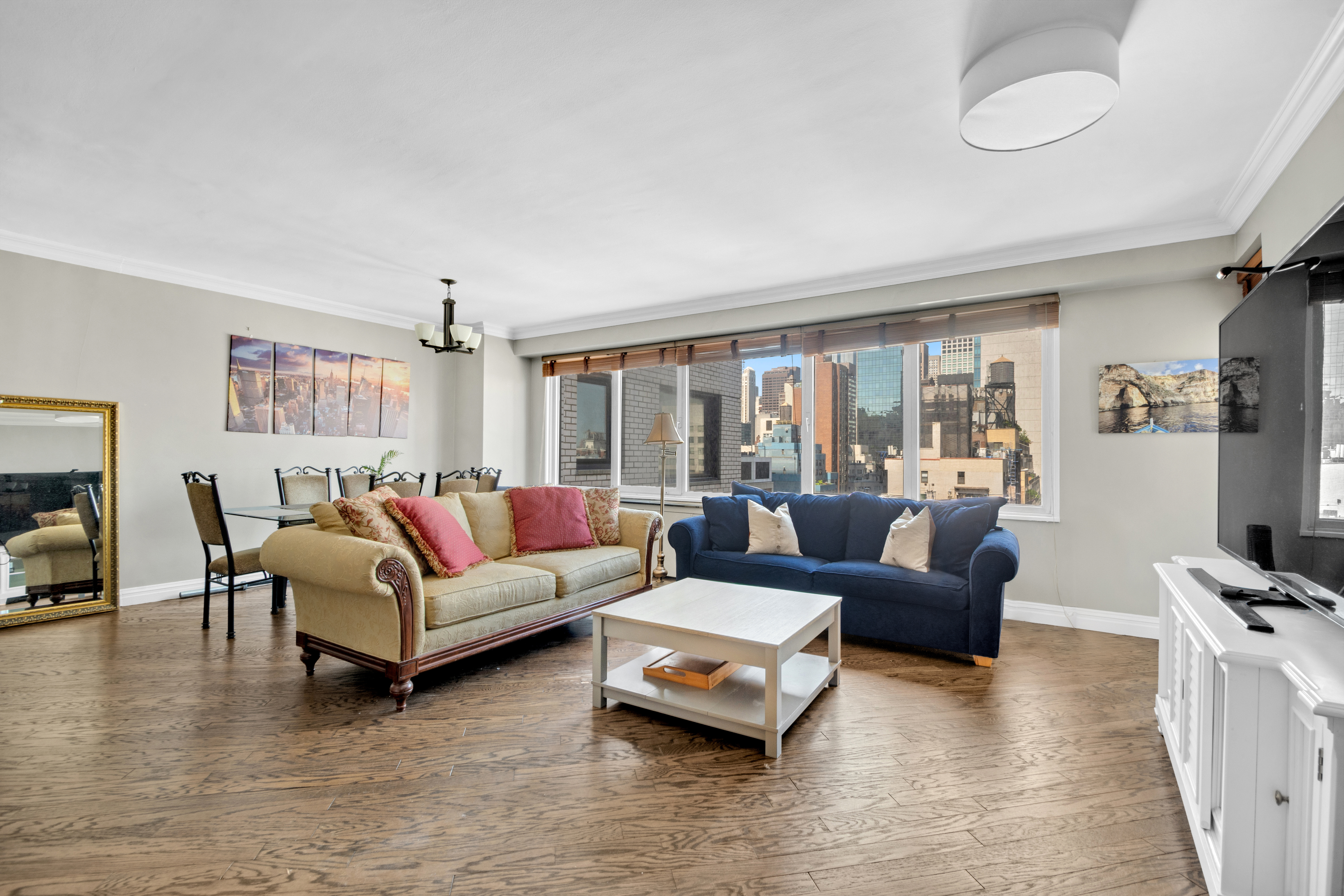 303 East 57th Street, Unit 17E Manhattan, NY 10022 - Photo 1 of 6 a living room with furniture and a flat screen tv
