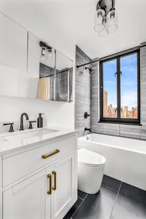 a bathroom with a sink a bathtub and a window