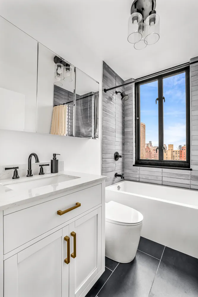 a bathroom with a sink a bathtub and a window