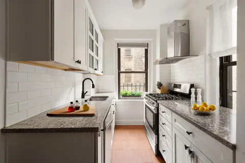 a kitchen with granite countertop a sink stainless steel appliances and cabinets