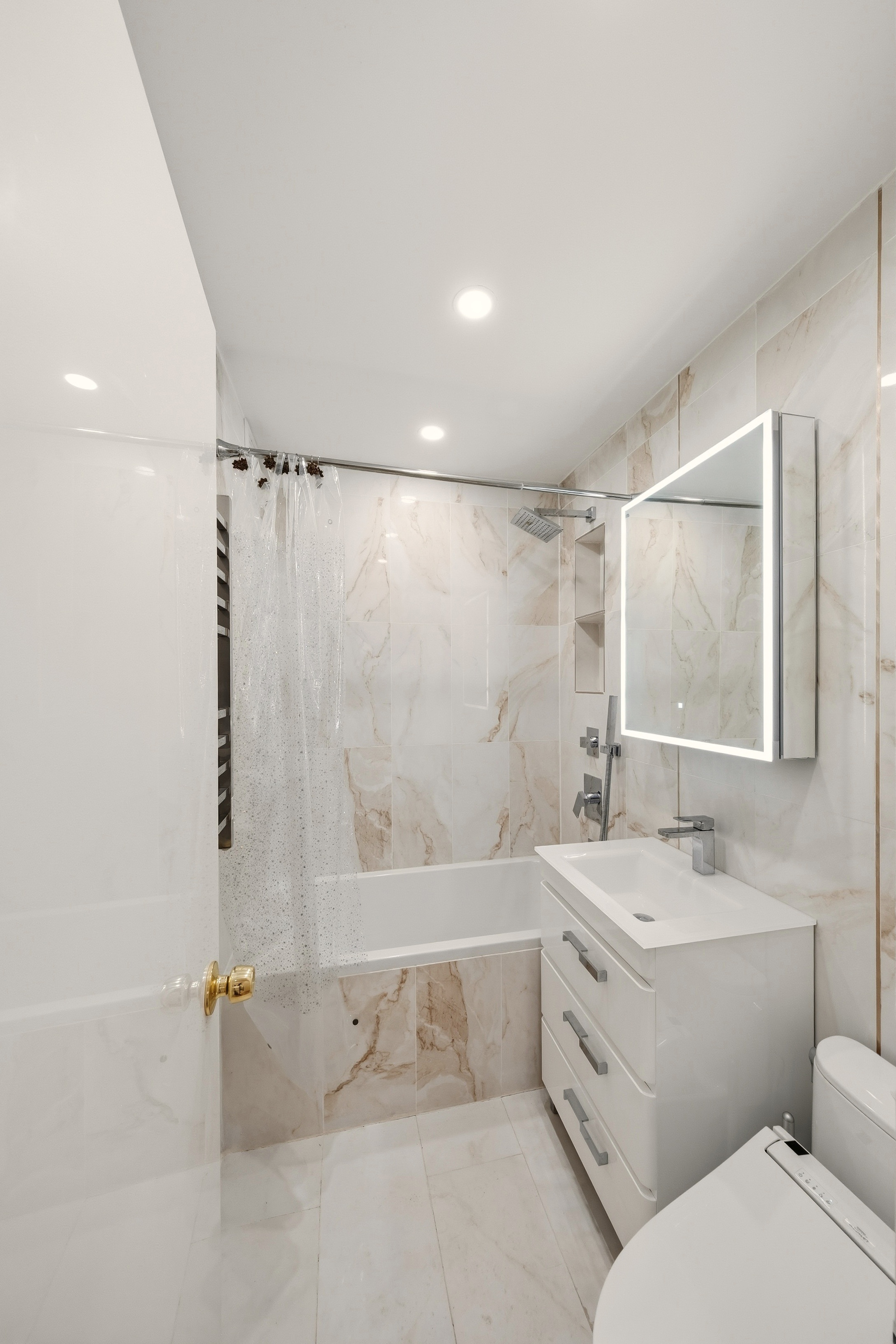 1577 East 17th Street, Unit 2F Brooklyn, NY 11230 - Photo 11 of 21 a bathroom with a double vanity sink toilet mirror and bathtub