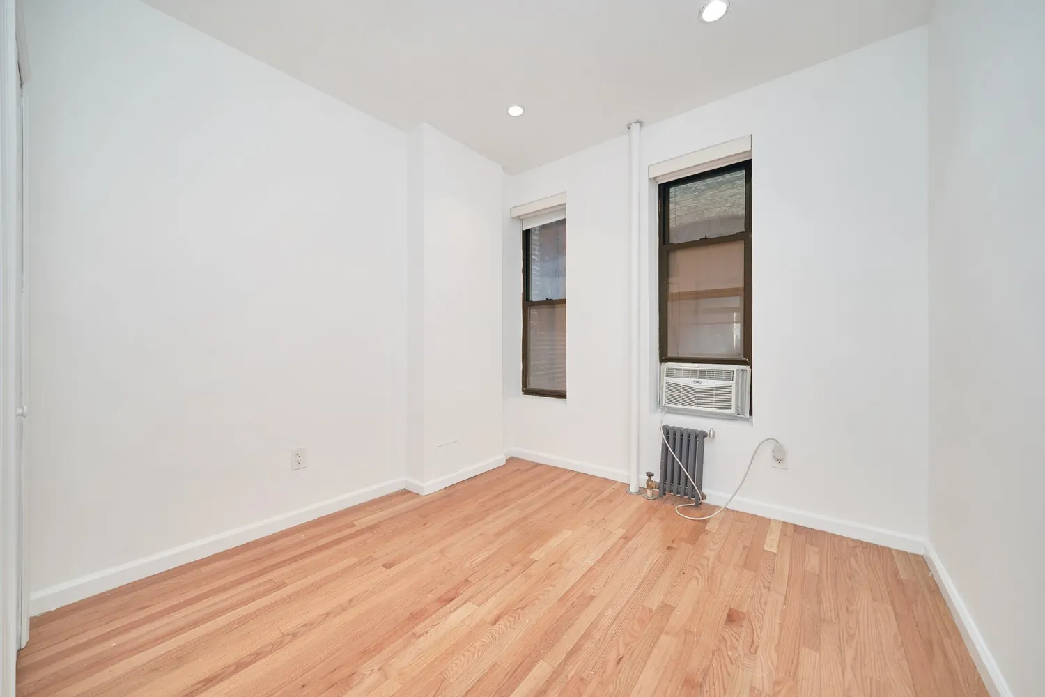 a view of empty room with wooden floor
