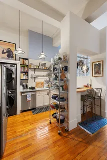 a kitchen with stainless steel appliances wooden floor and a refrigerator