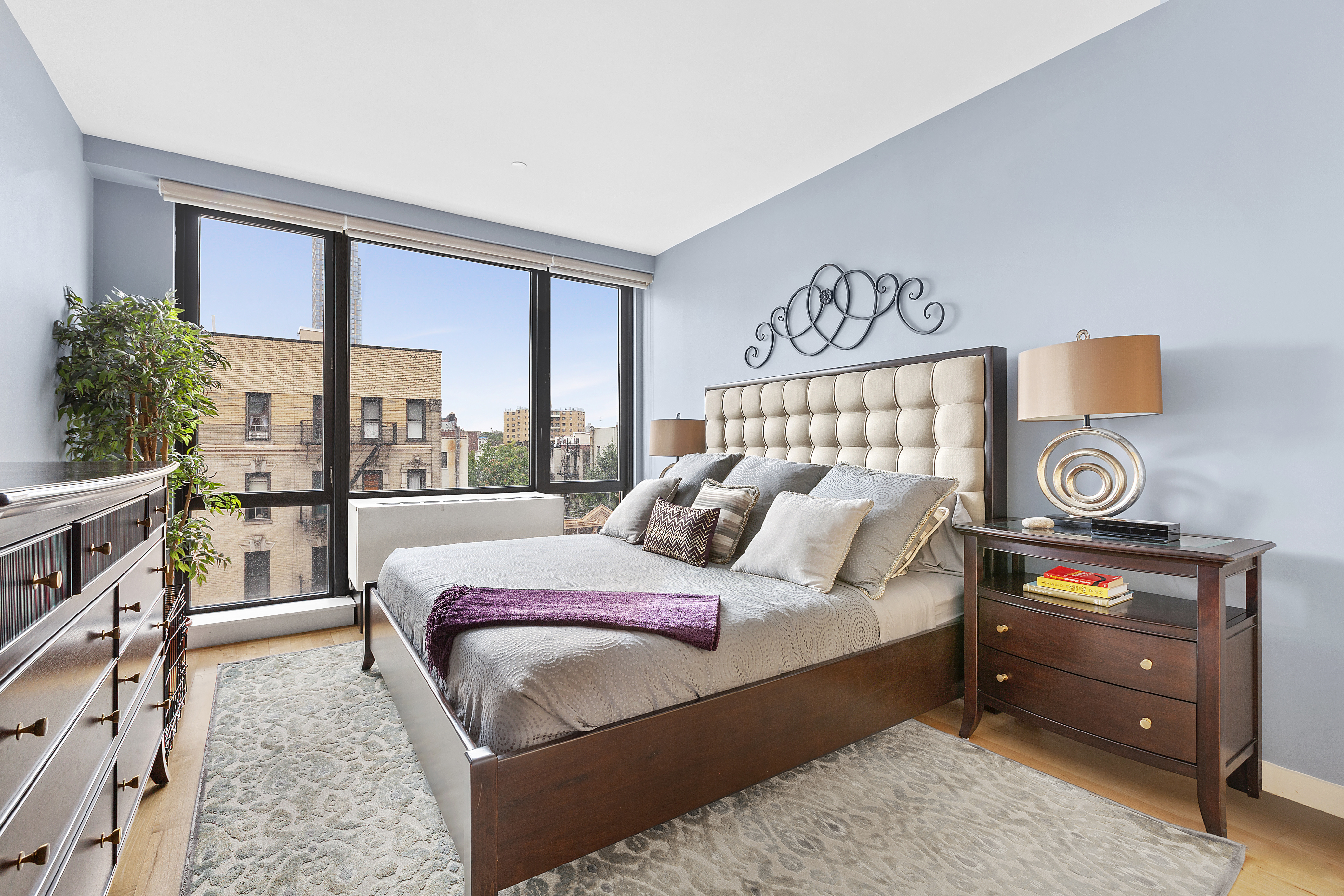 1595 Lexington Avenue, Unit 6E Manhattan, NY 10029 - Photo 4 of 13 a bedroom with a bed a bookshelf and a large window