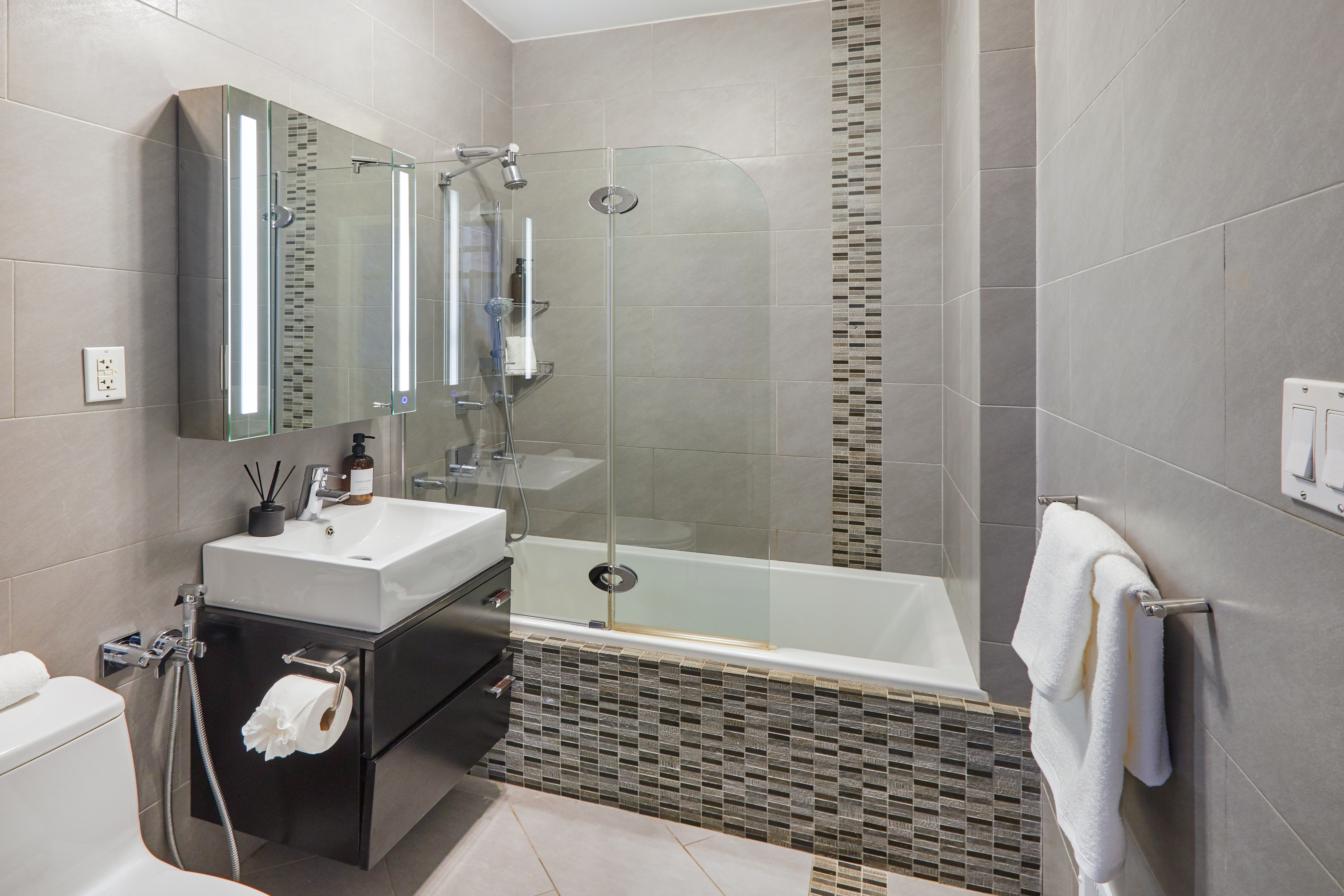 80 Leonard Street, Unit 3G Manhattan, NY 10013 - Photo 23 of 30 a bathroom with a sink a toilet a mirror and shower
