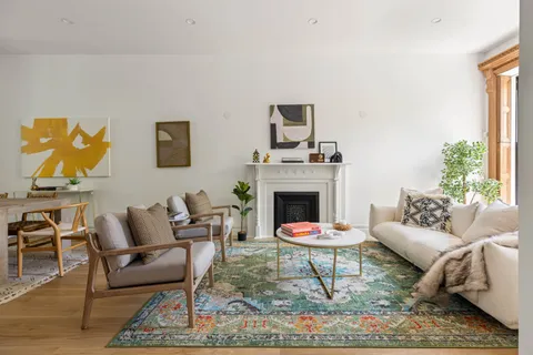 a living room with furniture a rug and a fireplace