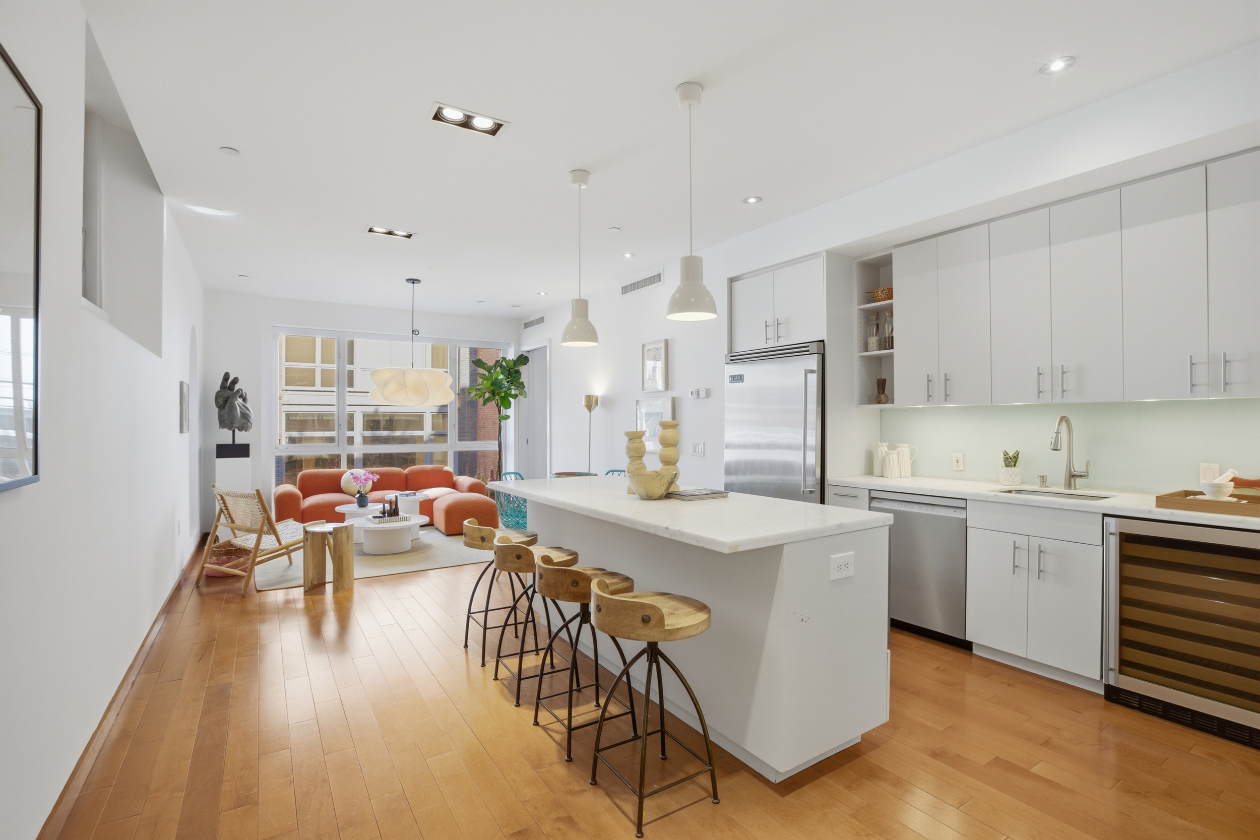 135 West 4th Street, Unit 2W Manhattan, NY 10012 - Photo 8 of 20 a kitchen with stainless steel appliances a stove a sink a oven a dining table and chairs with wooden floor