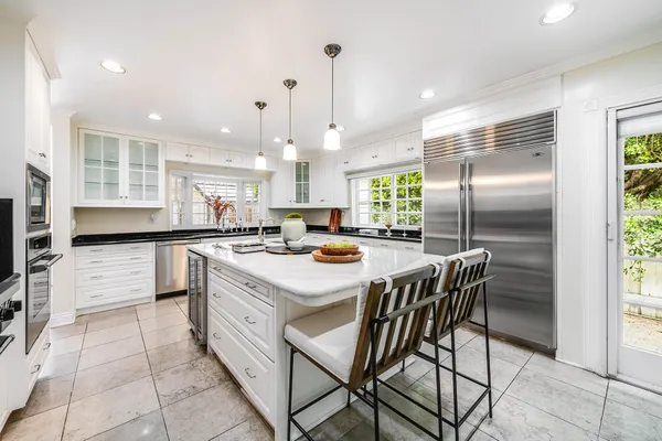 a kitchen with kitchen island a large counter top space appliances and cabinets