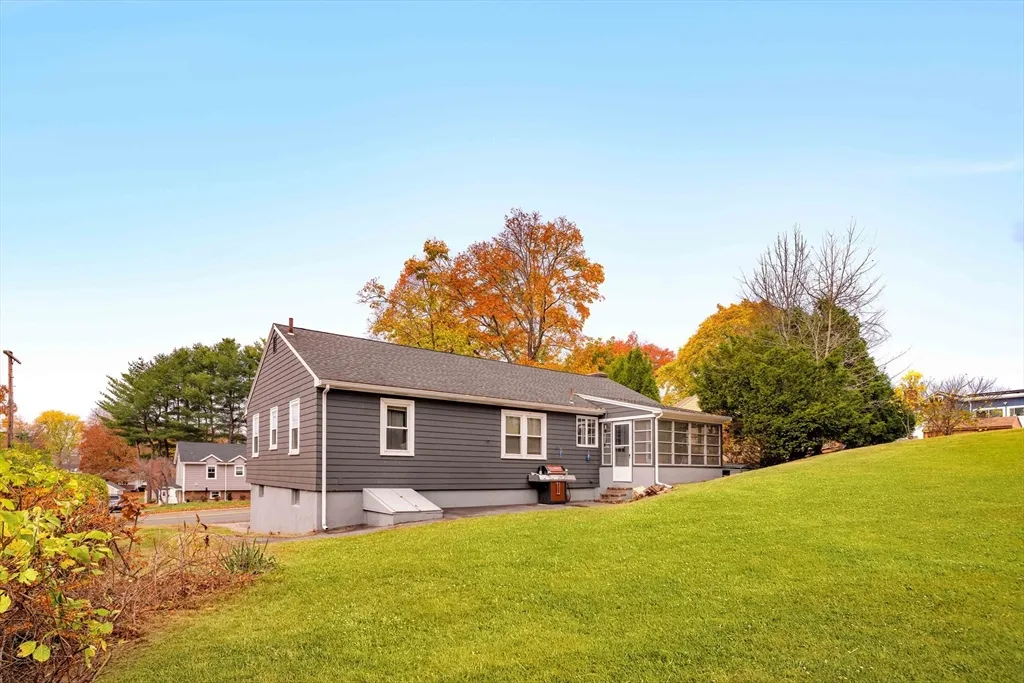 a front view of house with yard and trees in the background