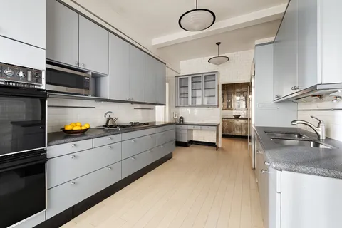 a kitchen with sink a stove and cabinets