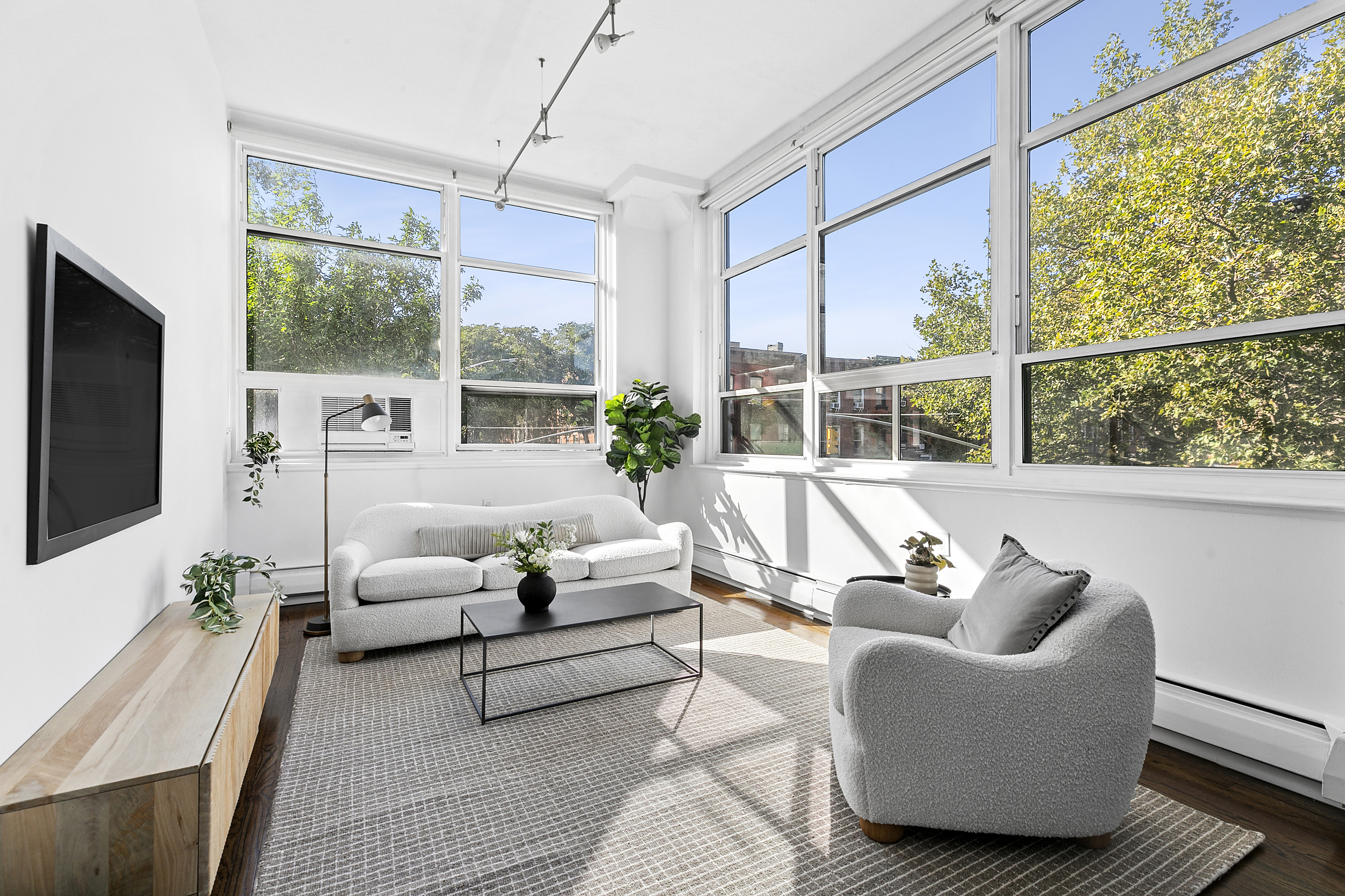 a living room with furniture a flat screen tv and a large window