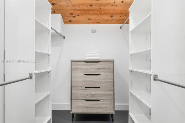 a view of walk in closet with empty racks
