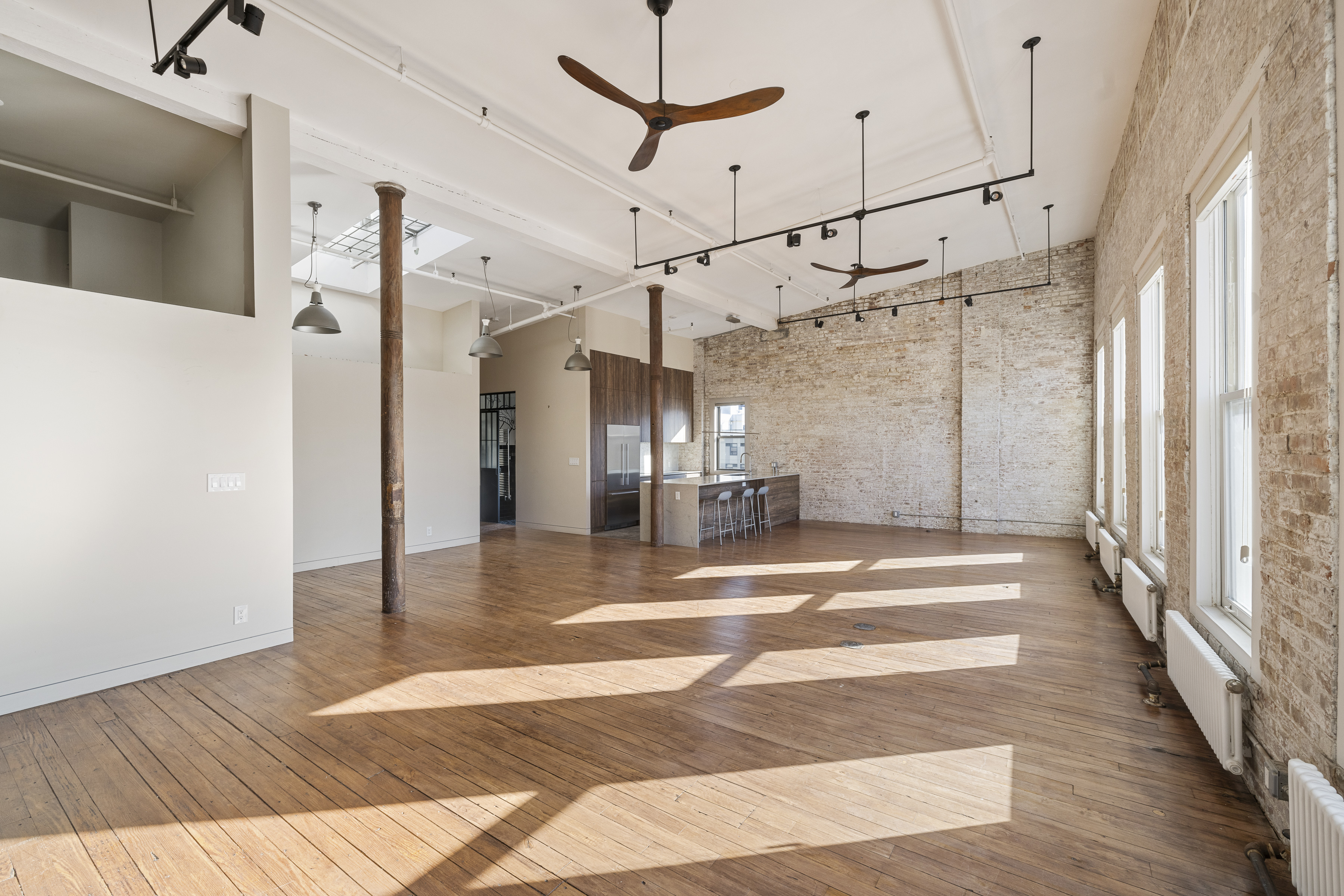 705 Driggs Avenue, Unit 13 Brooklyn, NY 11211 - Photo 5 of 15 a view of a hallway with wooden floor and a ceiling fan