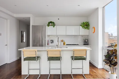 a white kitchen with a stove and white cabinets