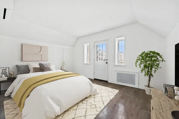 a spacious bedroom with a bed and a potted plant